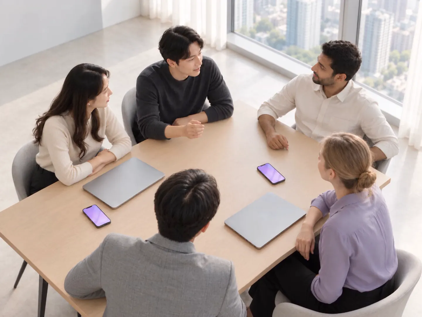 Five Korean and international colleagues around a meeting table, phones on the table